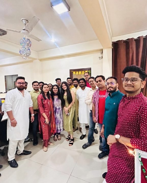 Colleagues in festive Indian outfits gathered together in the office.