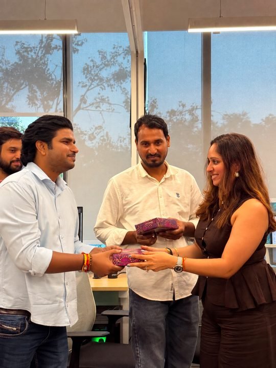 Gajender receiving a gift from a colleague during an office celebration.