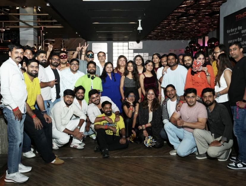 A big group of colleagues at a masquerade-themed annual party.